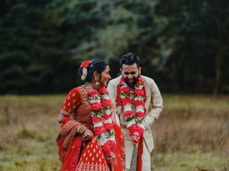 Dressed in traditional garments, an Indian couple laugh together during elopement